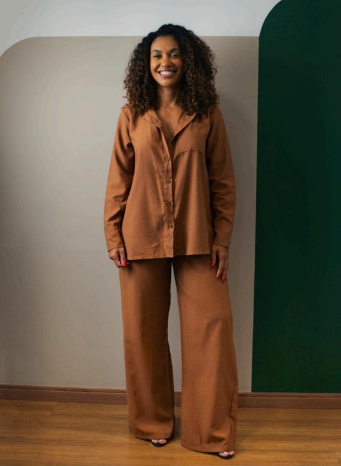 Cliente vestindo o Conjunto Ipê, camisa e calça pantalona em tom caramelo